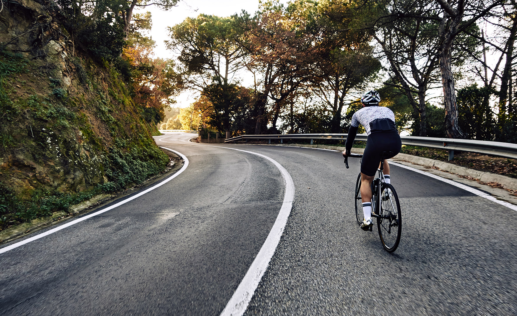 Ciclista a pedalar numa estrada ao ar livre. Ilustra a participação de atletas na 12.ª Edição do Grande Prémio de Ciclismo.